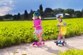 Kids riding scooter on sunny summer day