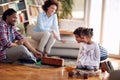 Kids riding skateboard on the floor and enjoying the playtime with their parents at home. Family, together, love, playtime