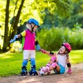 Kids roller skating in summer park Royalty Free Stock Photo