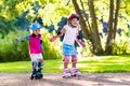 Kids roller skating in summer park Royalty Free Stock Photo