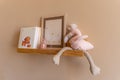 Kids room decor, wooden floating shelf interior child bedroom, empty wooden picture frame, books, blank canvas