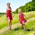 Kids running across green grass outdoor. Royalty Free Stock Photo