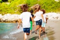 Kids running away along sandy beach in summer Royalty Free Stock Photo