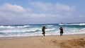 Kids running away from sea waves in winter jackets