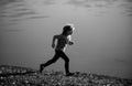 Kids running outdoors. Sporty young child jogging and training outdoor. Child running on summer field near lake, kids Royalty Free Stock Photo