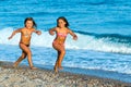 Kids running on pebble beach. Royalty Free Stock Photo