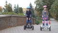 Kids in safety equipement riding gyroscooters in the park