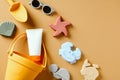 Kids sand molds, summer accessories and sunscreen cream bottle on sandy background