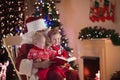 Kids and Santa at fire place on Christmas eve Royalty Free Stock Photo