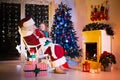 Kids and Santa opening Christmas presents Royalty Free Stock Photo