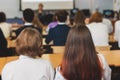 Kids in school writing and taking notes, teens pupils behind desks during the lesson listen to teacher lecture, classroom with Royalty Free Stock Photo