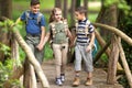 Kids scouts traveler with backpack hiking bridge in forest Royalty Free Stock Photo