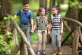 Kids scouts traveler with backpack hiking bridge in forest Royalty Free Stock Photo