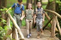 Kids scouts traveler with backpack hiking bridge in forest Royalty Free Stock Photo