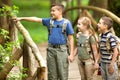 Kids scouts traveler with backpack hiking bridge in forest Royalty Free Stock Photo