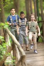 Kids scouts traveler with backpack hiking bridge in forest Royalty Free Stock Photo