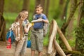 Kids scouts traveler with backpack hiking bridge in forest Royalty Free Stock Photo