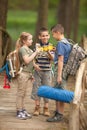 Kids scouts traveler with backpack hiking bridge in forest Royalty Free Stock Photo