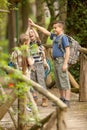 Kids scouts traveler with backpack hiking bridge in forest Royalty Free Stock Photo