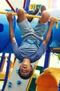 Kids see life differently. a young boy hanging upside down on a jungle gym in the park. Royalty Free Stock Photo