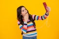 Kids selfie. Portrait of cute teenage girl using mobile phone, chatting on web, typing sms message. Mobile app for Royalty Free Stock Photo