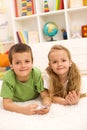 Kids sharing a music player laying on the floor Royalty Free Stock Photo