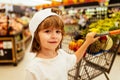 Kids shopping. Joyful beautiful child boy in supermarket buys vegetables. Healthy food for kids. Royalty Free Stock Photo