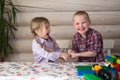 Kids siblings brother and sister playing constructor, share toys