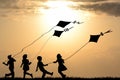 Kids silhouettes playing with kites