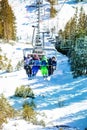 Kids sit on ski chairlift over forest and station Royalty Free Stock Photo