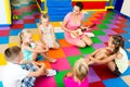 Kids sitting around teacher with small guitar Royalty Free Stock Photo