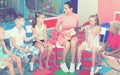 Kids sitting around teacher with small guitar Royalty Free Stock Photo