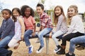 Kids sitting on a carousel in their schoolyard, side view