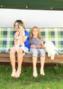 Kids sitting on a garden swing with dogs Royalty Free Stock Photo