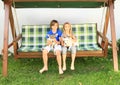 Kids sitting on a garden swing with dogs Royalty Free Stock Photo