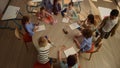 Kids sitting at round table at school. Diverse students preparing for lesson Royalty Free Stock Photo