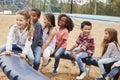 Kids sitting on a spinning carousel in their schoolyard Royalty Free Stock Photo