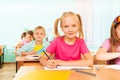 Kids sitting at table in classroom and writing Royalty Free Stock Photo