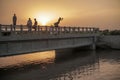 Kids Sitting Water From A Bridge During Sunset, In Moro