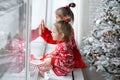 Kids are sitting on the windowsill by the window waiting for Christmas Royalty Free Stock Photo