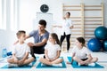 Kids sitting on yoga mats with their professional physician