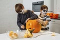 Kids with skull facepaint cutting a pumpkin