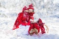 Kids sledding in winter forest. Children drink hot cocoa in snow Royalty Free Stock Photo