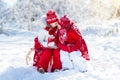 Kids sledding in winter forest. Children drink hot cocoa in snow