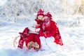 Kids sledding in winter forest. Children drink hot cocoa in snow Royalty Free Stock Photo