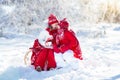 Kids sledding in winter forest. Children drink hot cocoa in snow Royalty Free Stock Photo