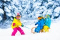 Kids on sleigh ride. Children sledding. Winter snow fun. Royalty Free Stock Photo