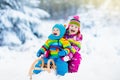 Kids on sleigh ride. Children sledding. Winter snow fun.