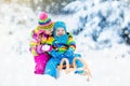 Kids on sleigh ride. Children sledding. Winter snow fun.