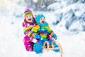 Kids on sleigh ride. Children sledding. Winter snow fun.